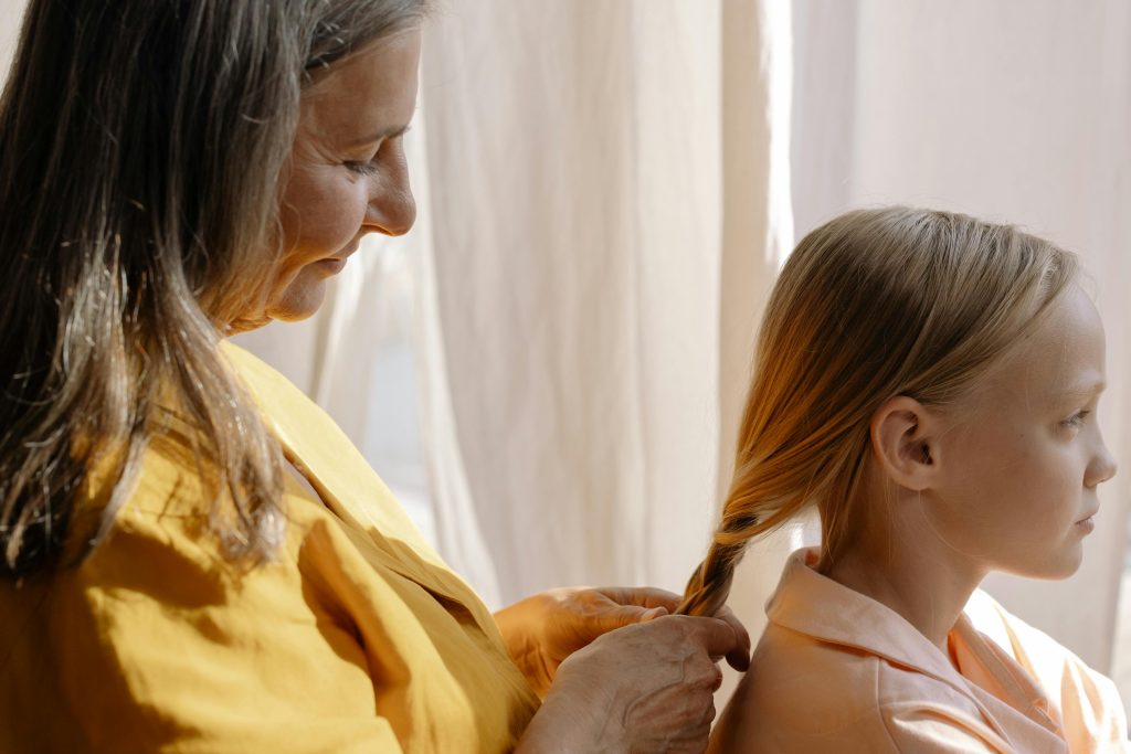 Mother's Day Brunch. A mother weaving her young daughter's hair into a braid.</p>
<p>Photo by Cottonbro via Pexels.com